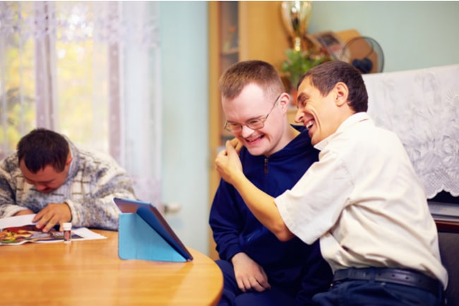 två vänner med funktionsnedsättning skrattar tillsammans