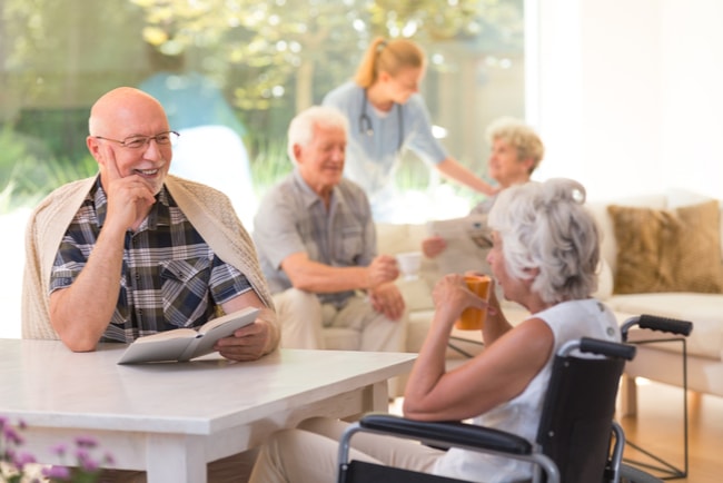 äldre man och kvinna vid bort i matsal på ett vårdboende